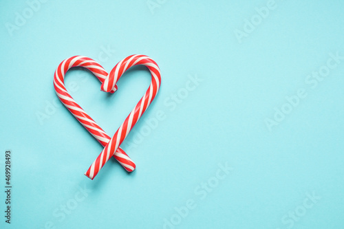 Christmas lollipops in the form of a heart on a blue background. Copy space