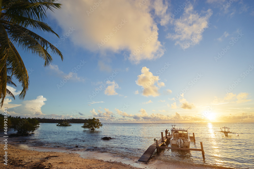 Beautiful seascape. Tropical sunrise on the beach. Wooden pier with te boat.
