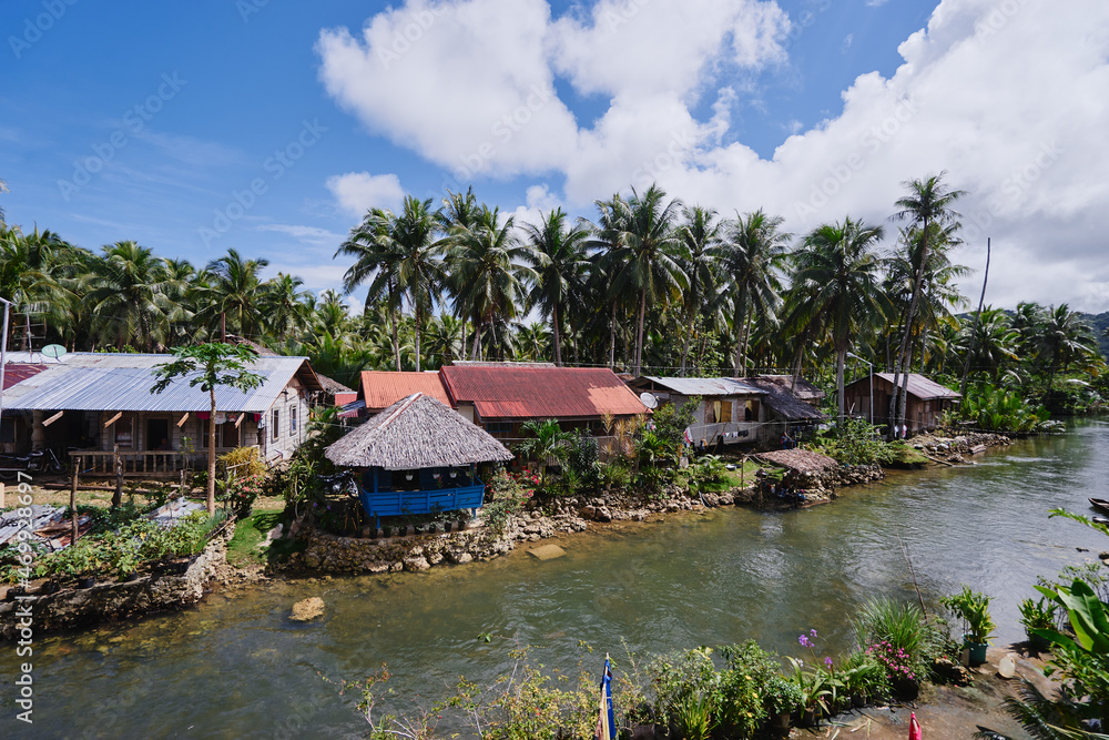 Wooden houses of tropical village on the river shore. Wooden houses of tropical village on the river shore.