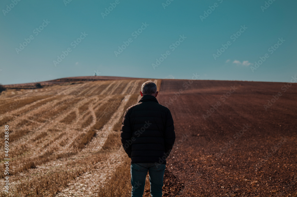 Portrait of adult man in winter cloth on field against blue sky. Shot in Castilla y Leon, Spain