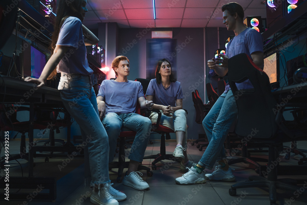 Team of professional gamers chatting with each other after winning tournaments Team of professional gamers chatting with each other after winning tournaments