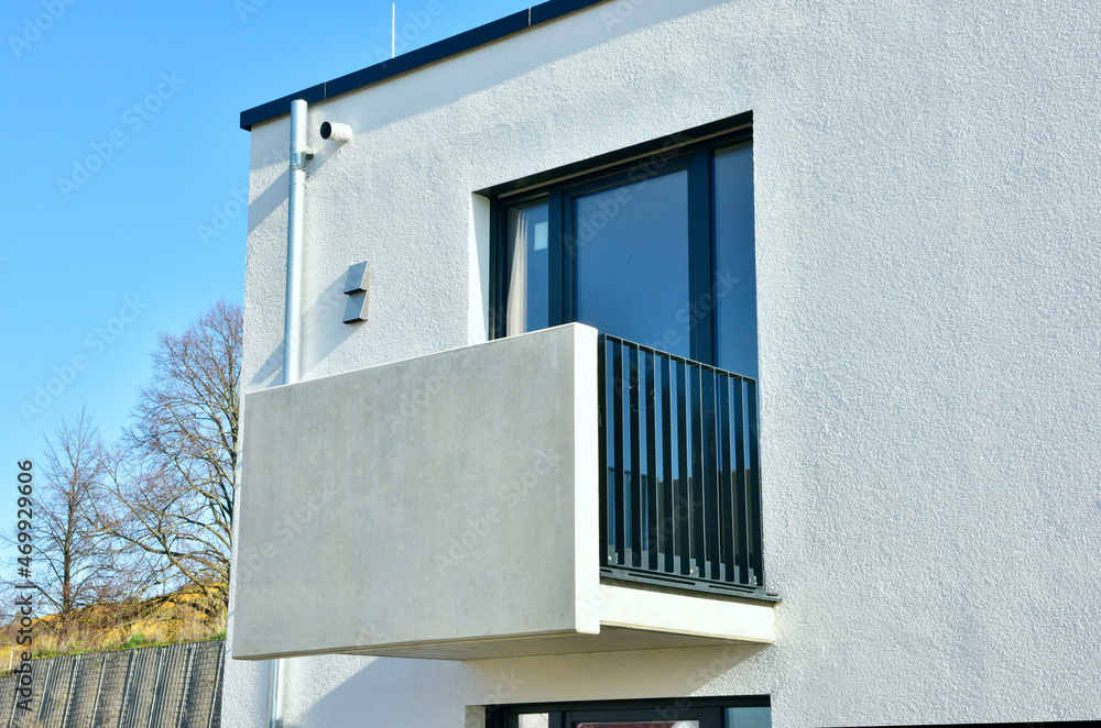 Moderne Betonbalkone mit beschichtetem Metall-Geländer und Attika-Blech als Mauerschutz an Neubau-Mehrfamilien-Hausfront