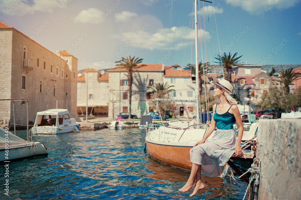 Tourism concept. Young traveling woman enjoying the view of Kastel Castle near the sea on Croatian coast.
