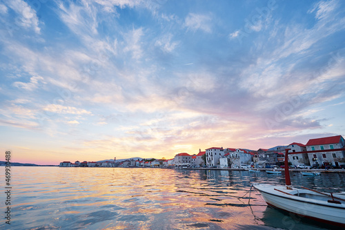 Beautiful sunset landscape. Fishing boat moored on Kastel coast in Dalmatia,Croatia.Old town near Adriatic sea.