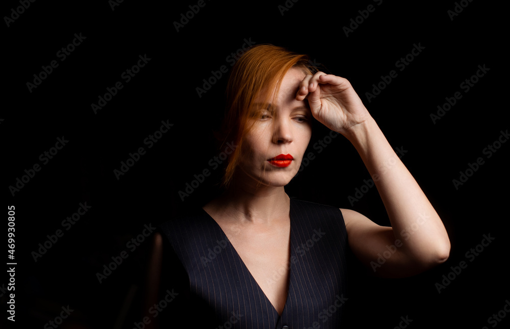 A middle-aged woman in her forties in mental decline, upset, thoughtful on a black background. Crisis concept.