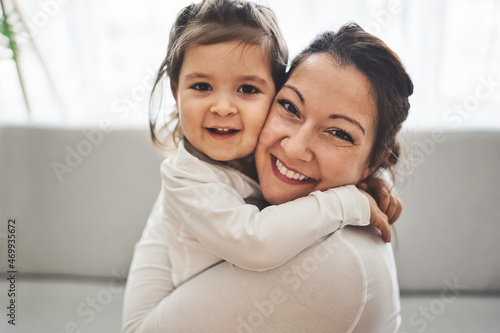 Mother with her daughter having fun in living room at home