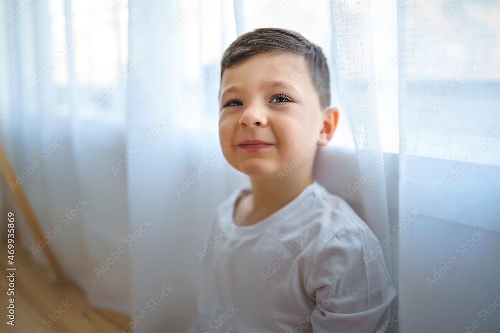 kid on the living room at home close to a window
