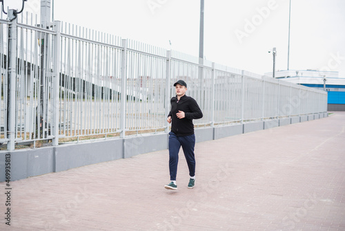young male sportsman jogger on the morning run outdoors