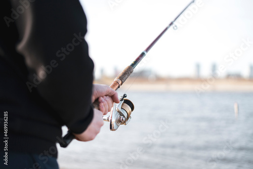 male person holding a fishing rod with bait, men leisure activity