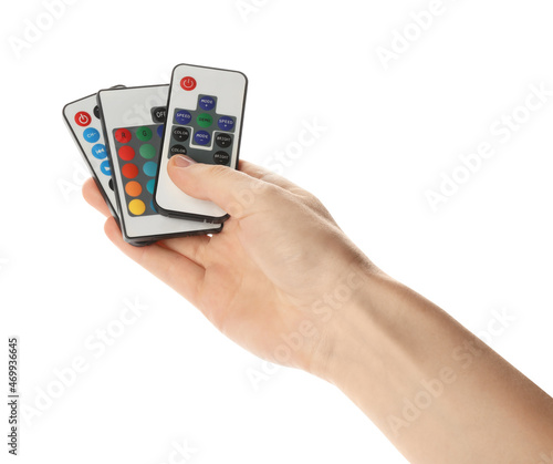 Woman holding remote controls on white background, closeup