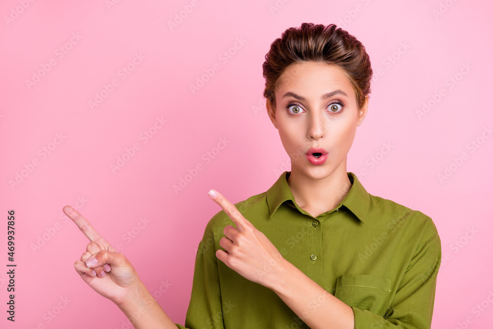 Photo of pretty impressed young woman dressed green shirt pointing fingers empty space isolated pink color background Photo of pretty impressed young woman dressed green shirt pointing fingers empty space isolated pink color background