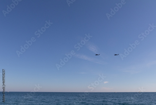 Military helicopters in the sky over the sea