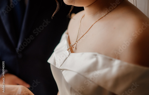 a cross necklace attached to a chinese woman's neck