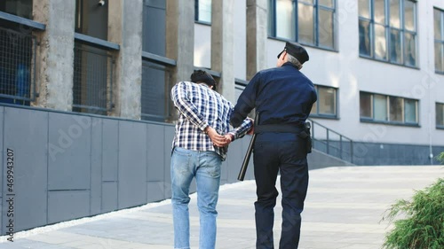 Arrest of the offender in the city. Detention of the accused man person. Police man leads a criminal. Detention of the accused