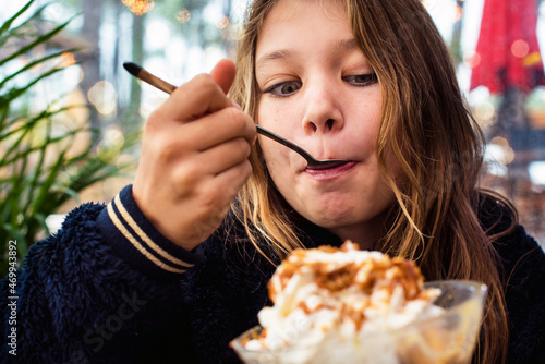 cute little girl enjoying a big cup of ice cream