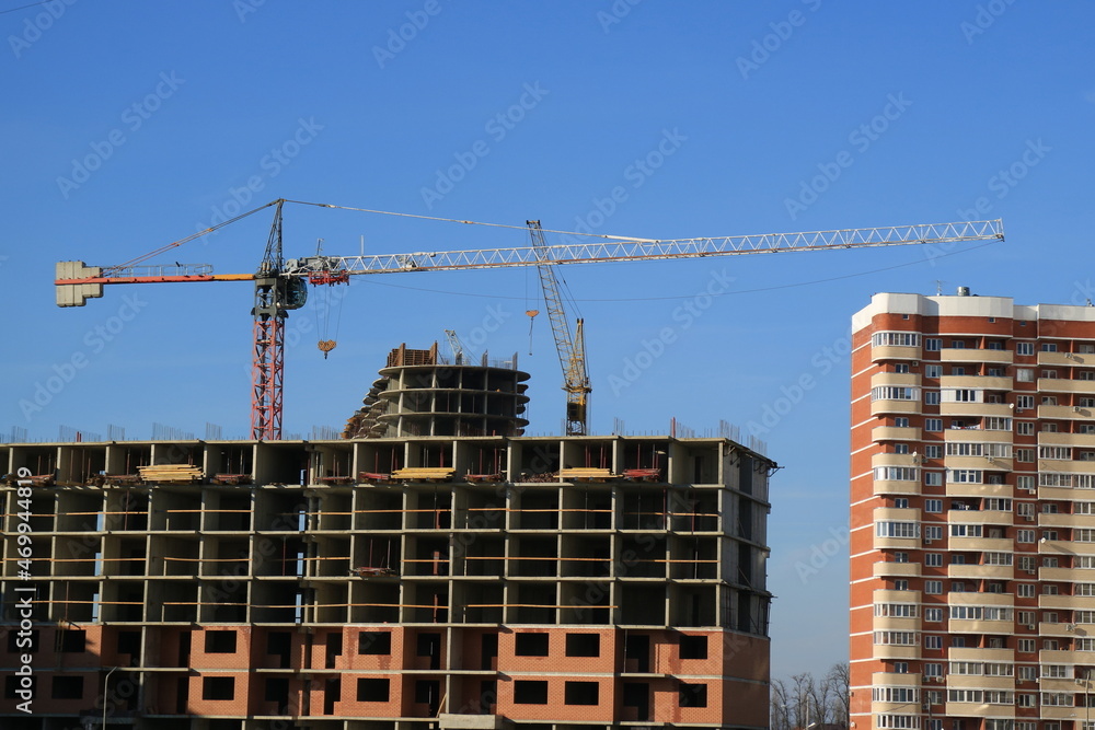 Tower cranes are working on the construction of a new house. Lifting crane. Tower cranes are working on the construction of a new house. Lifting crane.