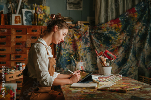 Artist drawing using tablet sitting at the table photo