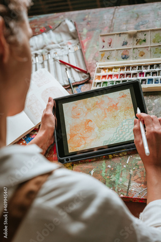 Close up of female artist or designer sketching on the digital tablet