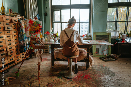 Backview of female artist working at her studio photo
