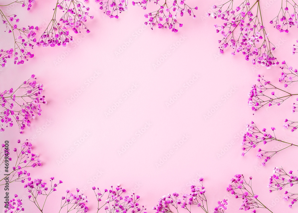 round frame wreath pattern with gypsophila flower, pink flower buds, branches and leaves on light pink background. flat lay, top view