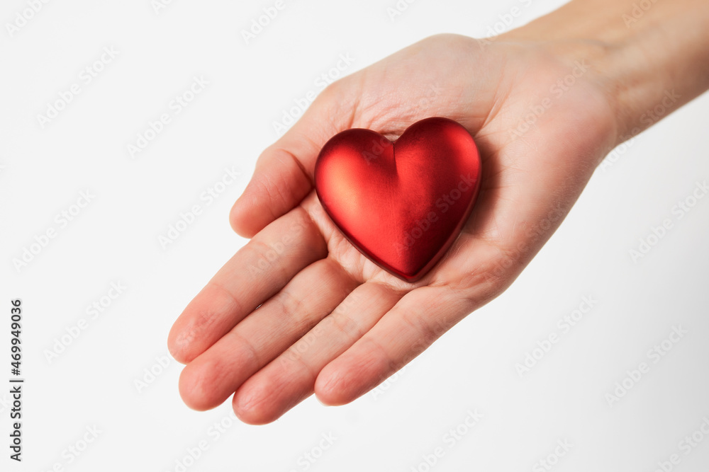 Hands holding red heart, close-up, white background