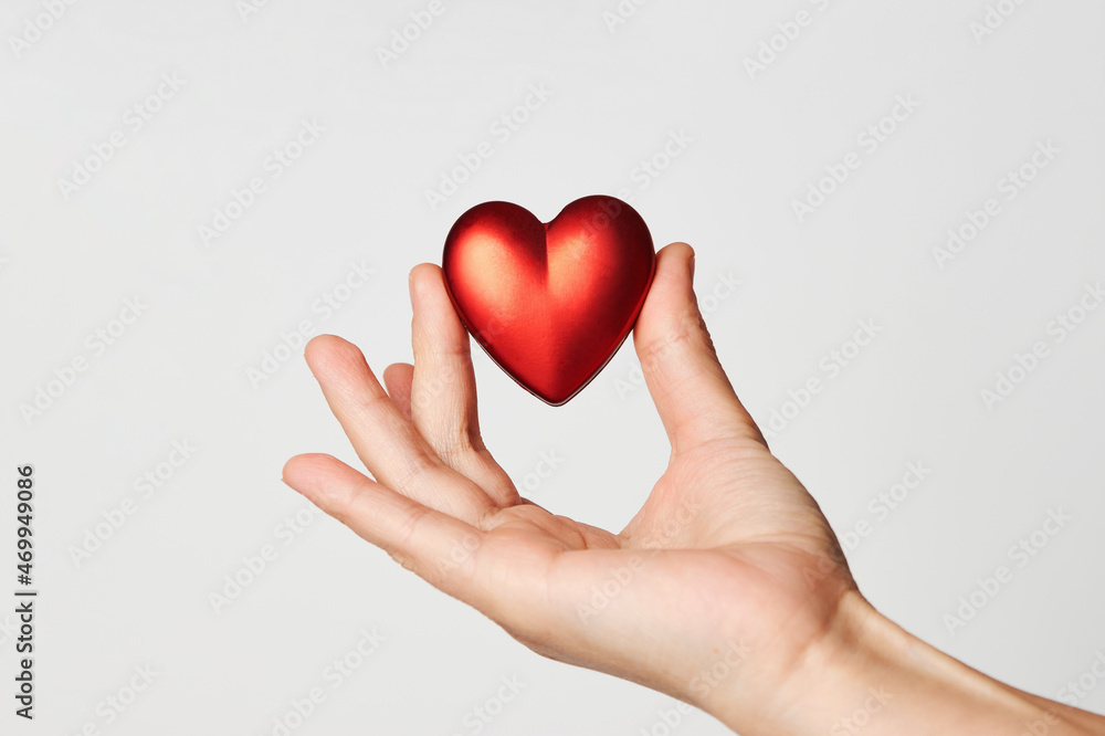 Obraz premium Hands holding red heart, close-up, white background