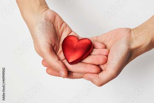 Fototapeta Naklejka Na Ścianę i Meble -  Hands holding red heart, close-up, white background