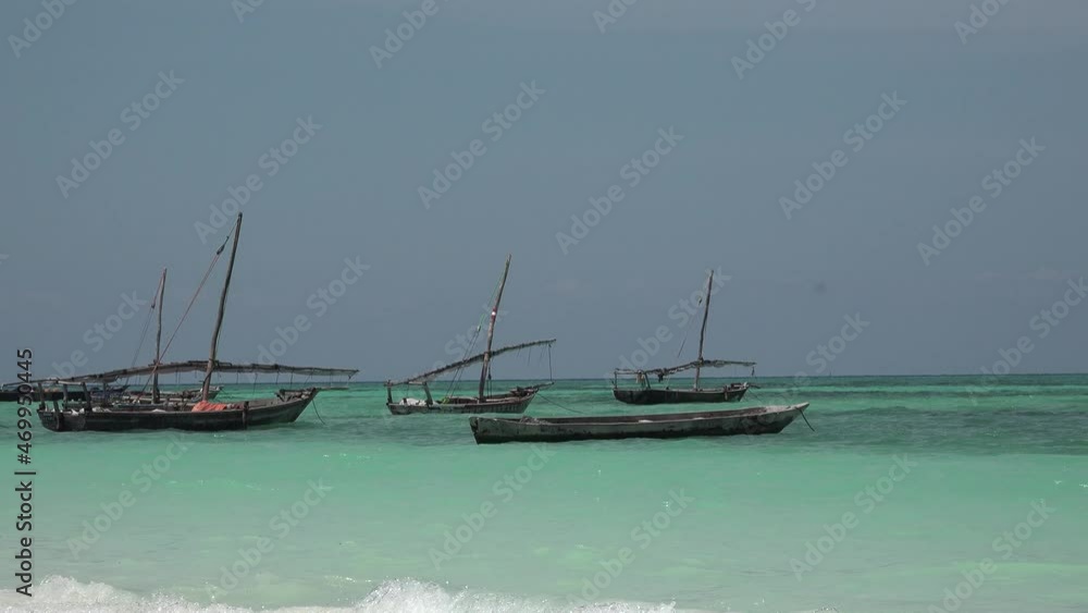 Boats of African fishermen in the Indian Ocean. Lot of African traditional wooden boats anchored on shallow water by the beach at low tide, Zanzibar. Boats of African fishermen in the Indian Ocean. Lot of African traditional wooden boats anchored on shallow water by the beach at low tide, Zanzibar.