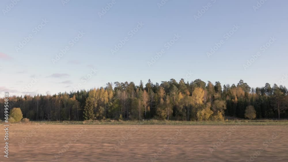Beautiful autumn day and the view from the car. Gorgeous landscape with fields, forest trees and blue sky with white clouds. Sweden. Beautiful autumn day and the view from the car. Gorgeous landscape with fields, forest trees and blue sky with white clouds. Sweden.