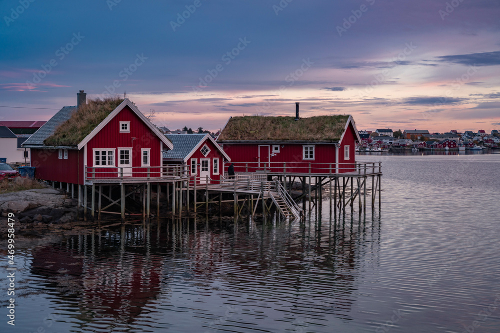 Red houses in the village of Reine, Lofoten at sunset. Beautiful postcard of the Arctic Circle of Norway.