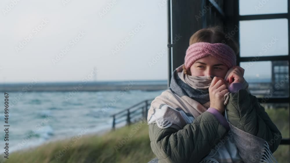 Woman in warm clothes wraps up in the scarf at the winter sea beach. Traveller woman is at the northern seashore, 4k 60p Woman in warm clothes wraps up in the scarf at the winter sea beach. Traveller woman is at the northern seashore, 4k 60p