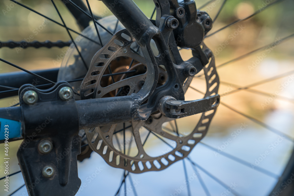 Fototapeta premium Bicycle rear wheel disc brake system. Cycling (Bike) trip on a dirt road in the forest. Sport and active life concept in spring and summer.
