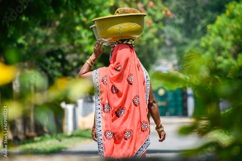 Photography Asian Woman carrying vegetables in head for sell