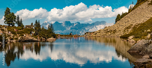 Fototapeta Naklejka Na Ścianę i Meble -  High resolution panorama of a beautiful alpine summer view with reflections and the famous Dachstein mountains in the background at the Spiegelsee, Reiteralm, Pichl, Schladming, Steiermark, Austria