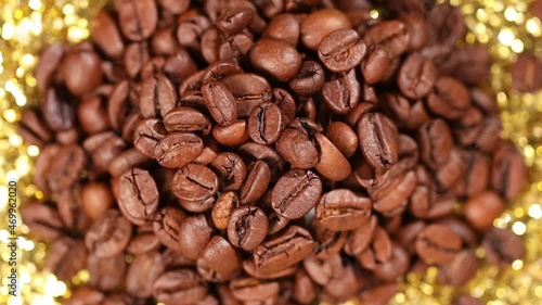 Fragrant coffee beans rotate on a golden background.