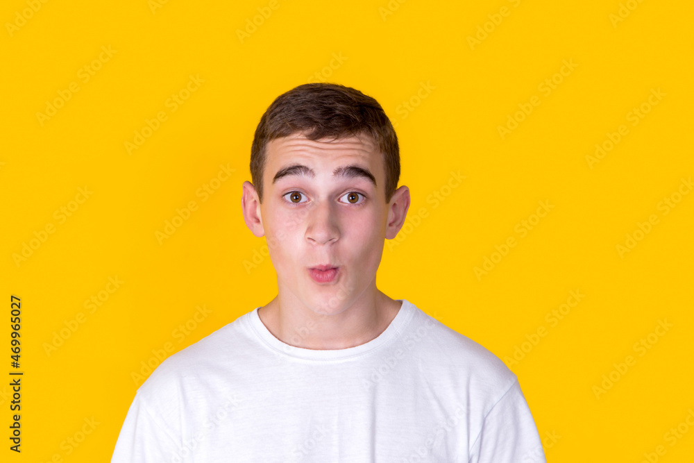 A funny handsome guy in a white t-shirt   on a yellow background