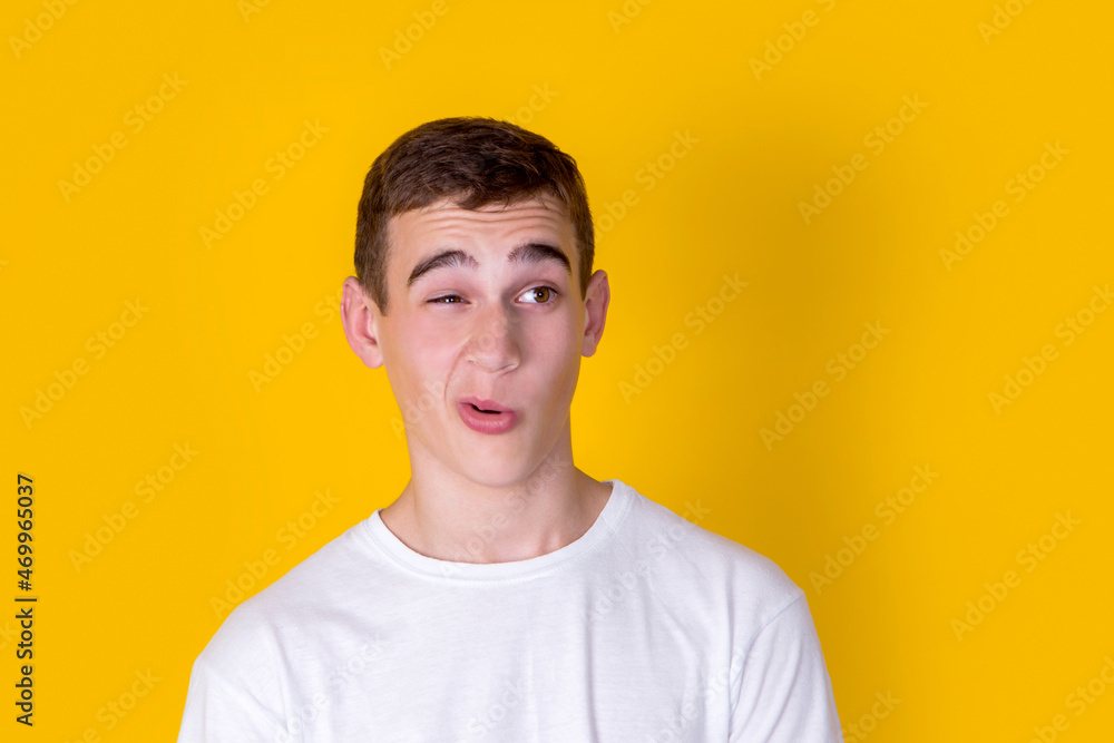 A funny handsome guy in a white t-shirt on a yellow background A funny handsome guy in a white t-shirt on a yellow background