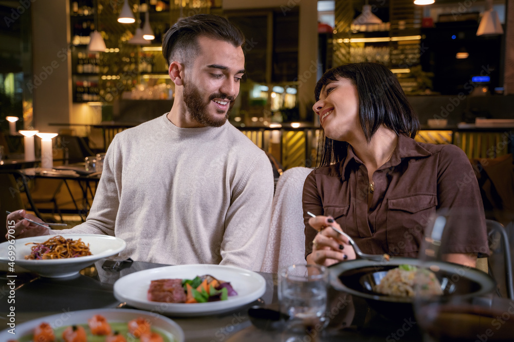 Young couple dining at fusion restaurant - couple of young lovers eating asian food
