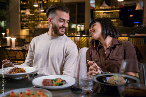 Young couple dining at fusion restaurant - couple of young lovers eating asian food
