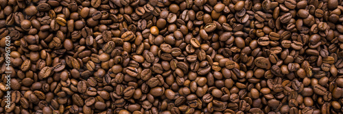 Fresh brown coffee beans background. Closeup. Empty place for text. Wide banner. Top down view.