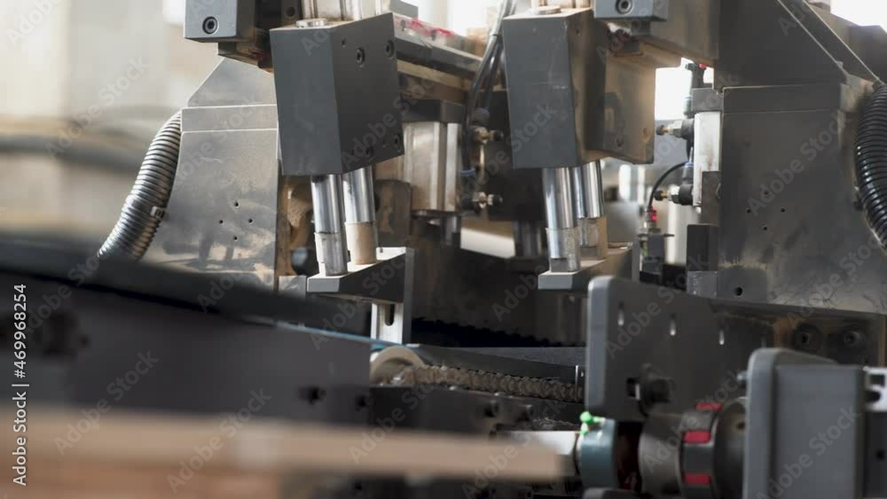 Production process in a furniture factory, woodworking machine mechanism close up. Workflow in a furniture factory. Woodworking factory Production process in a furniture factory, woodworking machine mechanism close up. Workflow in a furniture factory. Woodworking factory