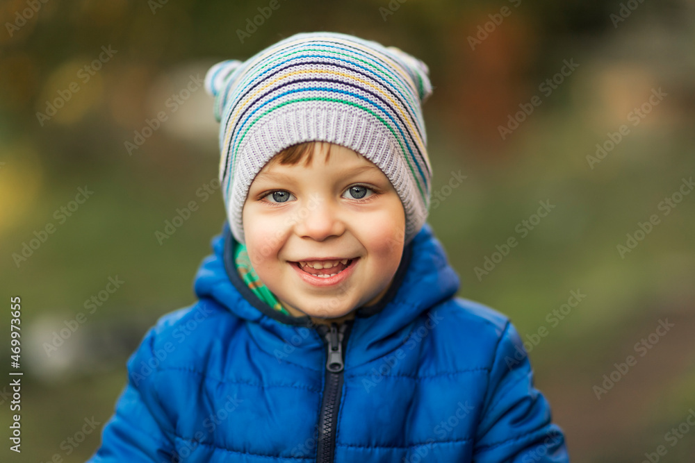 Little boy with blue eyes and blue jacket laughing outdoor Little boy with blue eyes and blue jacket laughing outdoor