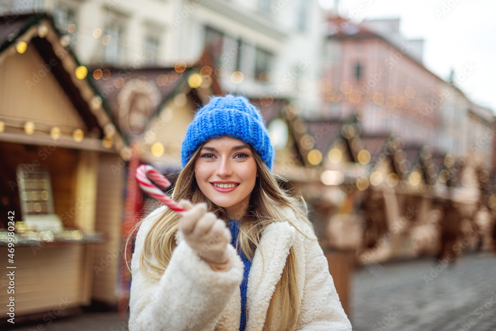 Christmas, New Year, winter holidays conception: happy smiling woman walking at street festive fair, holding candy cane. Outdoor lifestyle portrait. Copy, empty space for text
Christmas, New Year, winter holidays conception: happy smiling woman walking at street festive fair, holding candy cane. Outdoor lifestyle portrait. Copy, empty space for text