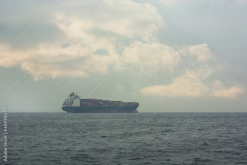 freighter in a cloudy sky and sea