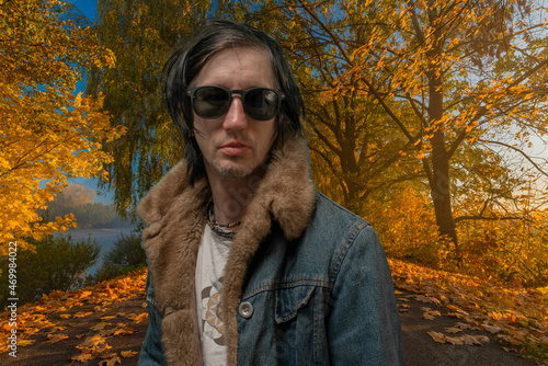 Man with black hair and sunglasses in sunrise autumn alley of leaf trees © luzkovyvagon.cz