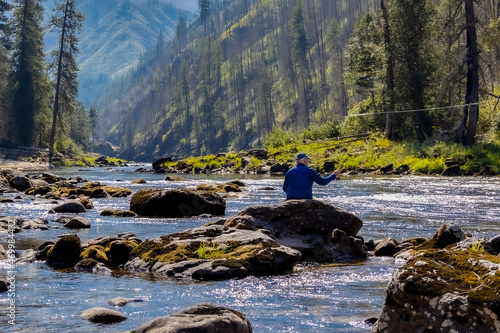 Man wading and fly fishing in the Selway River in the Idaho Selway Bitterroot wilderness. photo