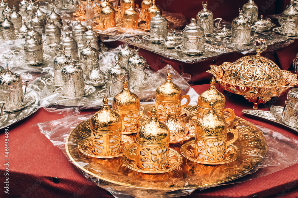 Traditional turkish coffee serving set at souvenir stall. Metal ornamental coffee set - symbol of turkish cofee culture. Popular souvenir and present from Turkey. Selective focus