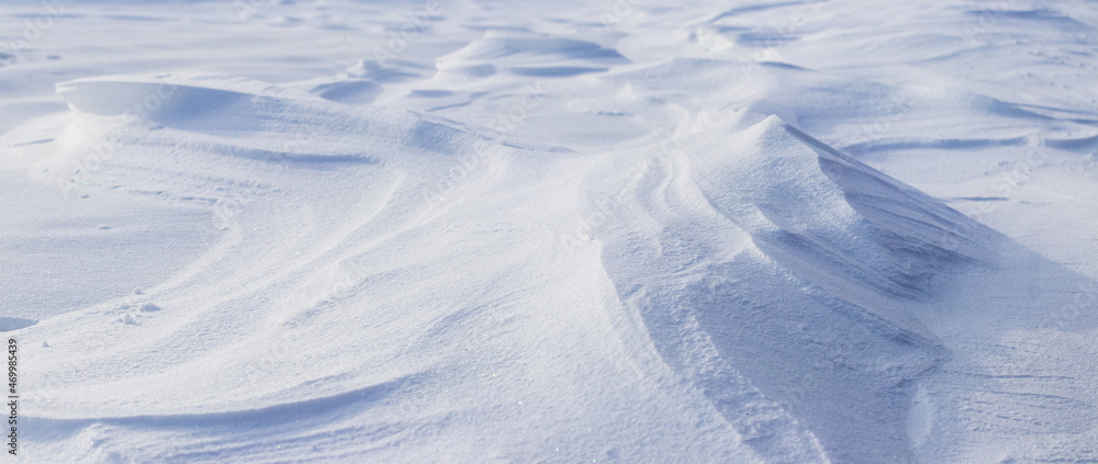 Snowy background, snow-covered surface of the earth after a blizzard in the morning in the sunlight with distinct layers of snow Snowy background, snow-covered surface of the earth after a blizzard in the morning in the sunlight with distinct layers of snow