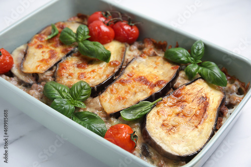 Delicious eggplant lasagna in baking dish on white marble table  closeup