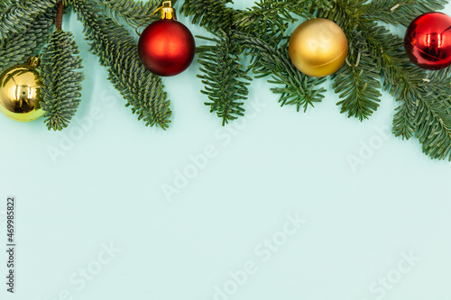 New Year's background. Christmas decorations and fir branches on a blue background. Top view.
